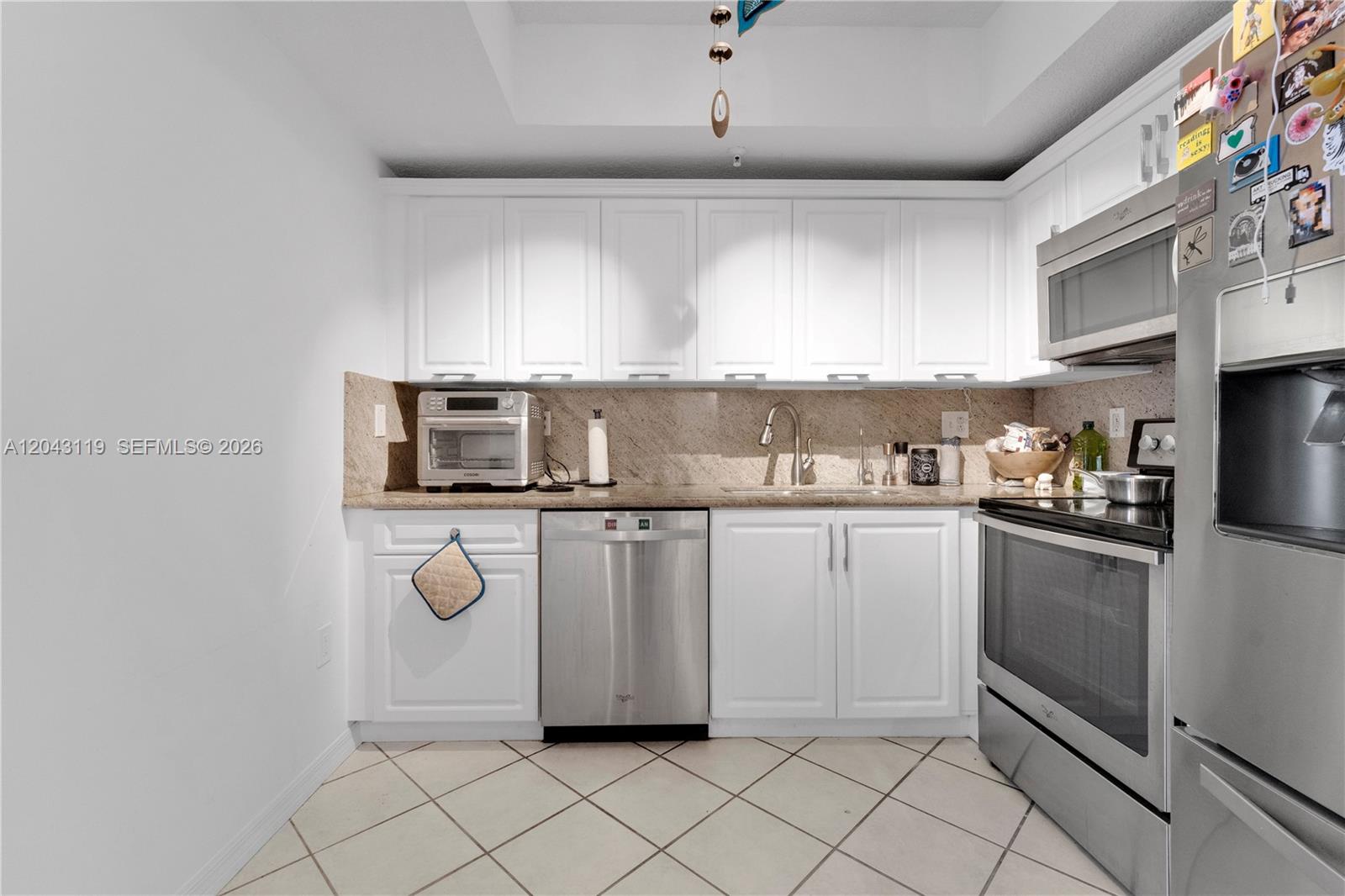 A kitchen features white cabinets, stainless steel appliances, and a tan granite countertop — 3500 Coral Way # 10, Miami FL 33145, MIAMI, FL