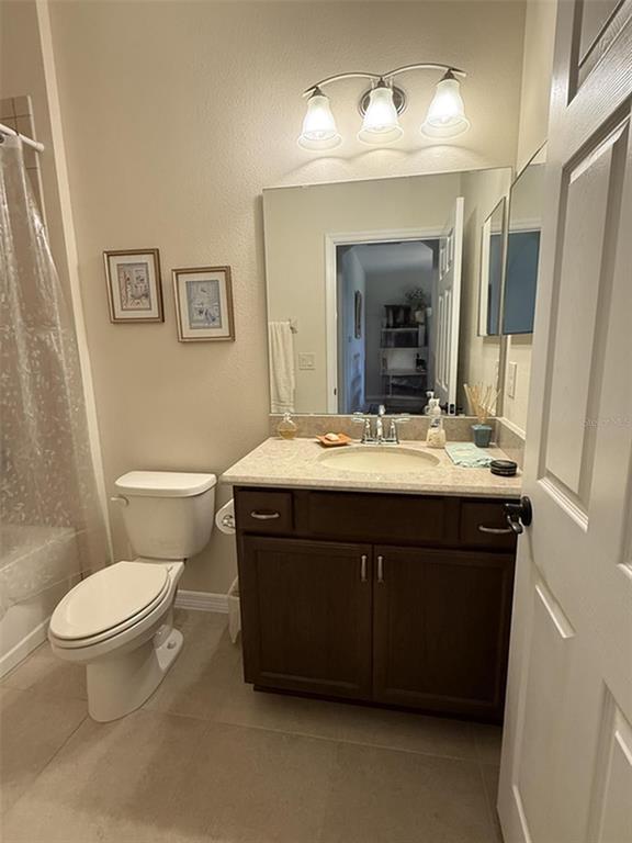 A bathroom features a dark wood vanity, a beige countertop, and a white toilet — 4546 SHENANDOAH RIVER TRAIL, LEESBURG, FL