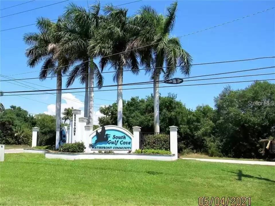 A sign for South Gulf Cove waterfront community stands behind a lawn with palm trees — 13357 AMARYLLIS CIR, PORT CHARLOTTE, FL