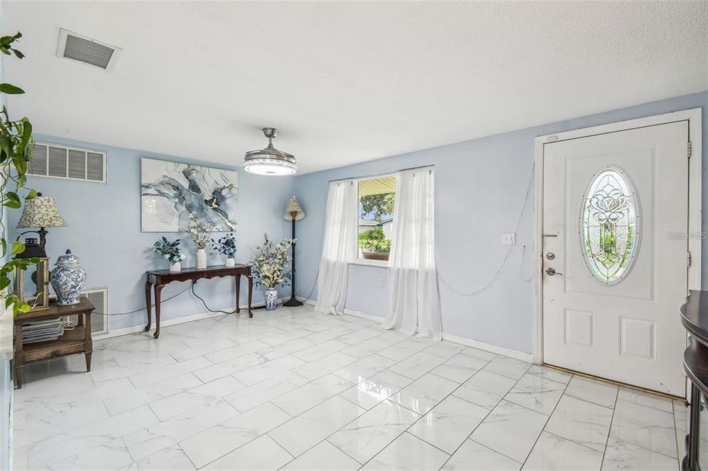 A patio area features a round dining table, a tiki bar, and a vine-covered pergola — 1627 DANDER DRIVE, HOLIDAY, FL