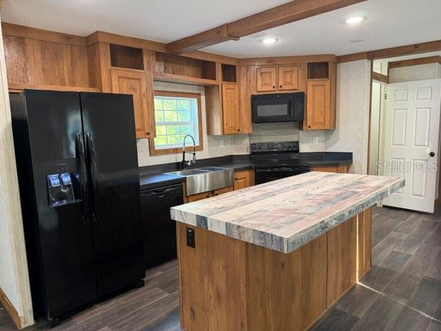 A kitchen features wood cabinets, a black refrigerator, and a large island with a countertop — 113 MAGNOLIA AVENUE, HAWTHORNE, FL