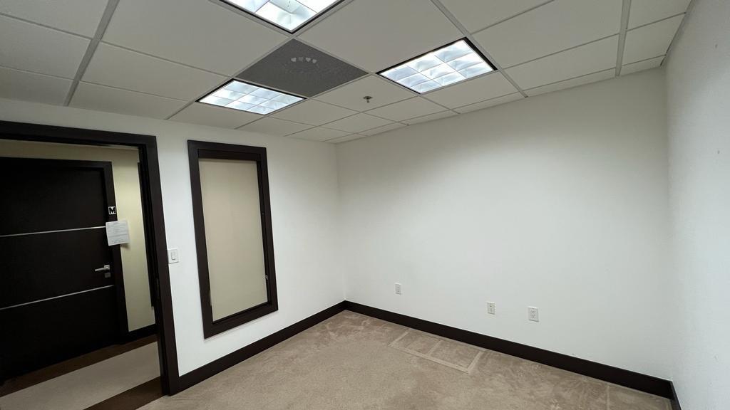 An empty office room features white walls, dark trim, carpeted flooring, and a drop ceiling — 2730 SW 3rd Avenue # 202N, Miami FL 33129, MIAMI, FL