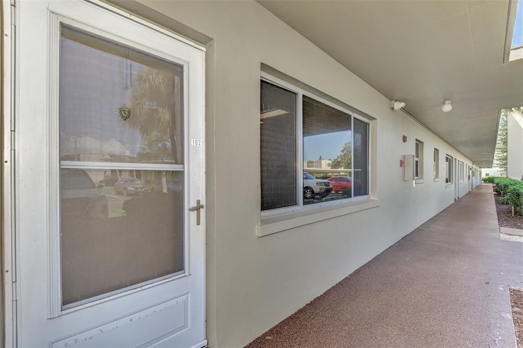 A ground-level exterior walkway leads to a white door labeled 102 with a window nearby — 4460 IRONWOOD CIRCLE UNIT 102A, BRADENTON, FL