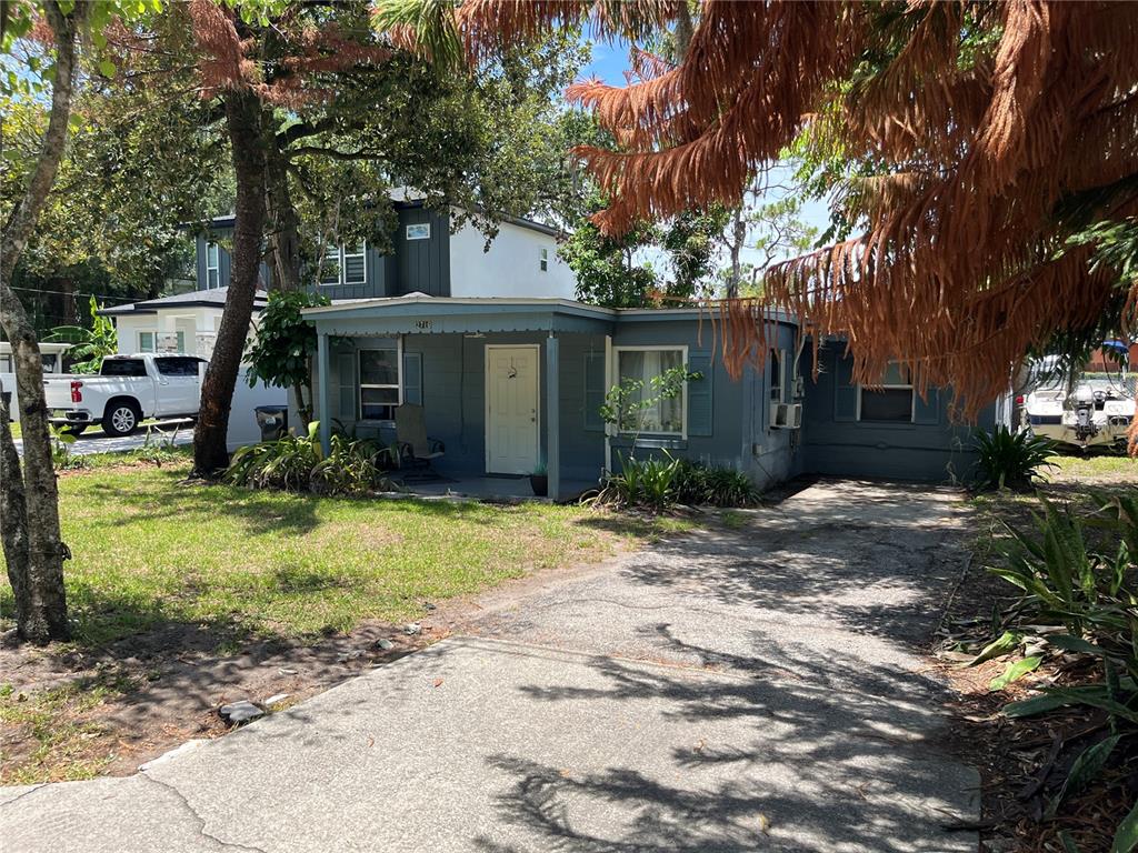 A single-story blue house with a covered front porch and a concrete driveway — 884 E MICHIGAN STREET, ORLANDO, FL