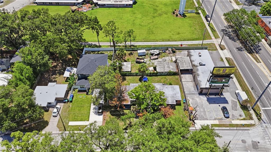 An aerial view shows a residential property adjacent to a commercial building with a billboard — 884 E MICHIGAN STREET, ORLANDO, FL