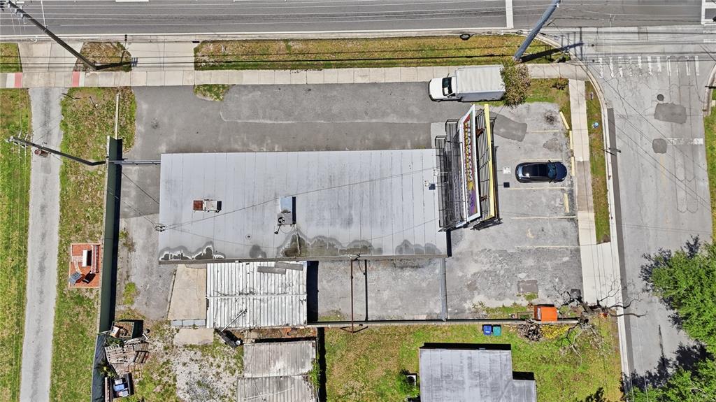 An aerial view shows a commercial building with a large billboard and parking lot — 884 E MICHIGAN STREET, ORLANDO, FL