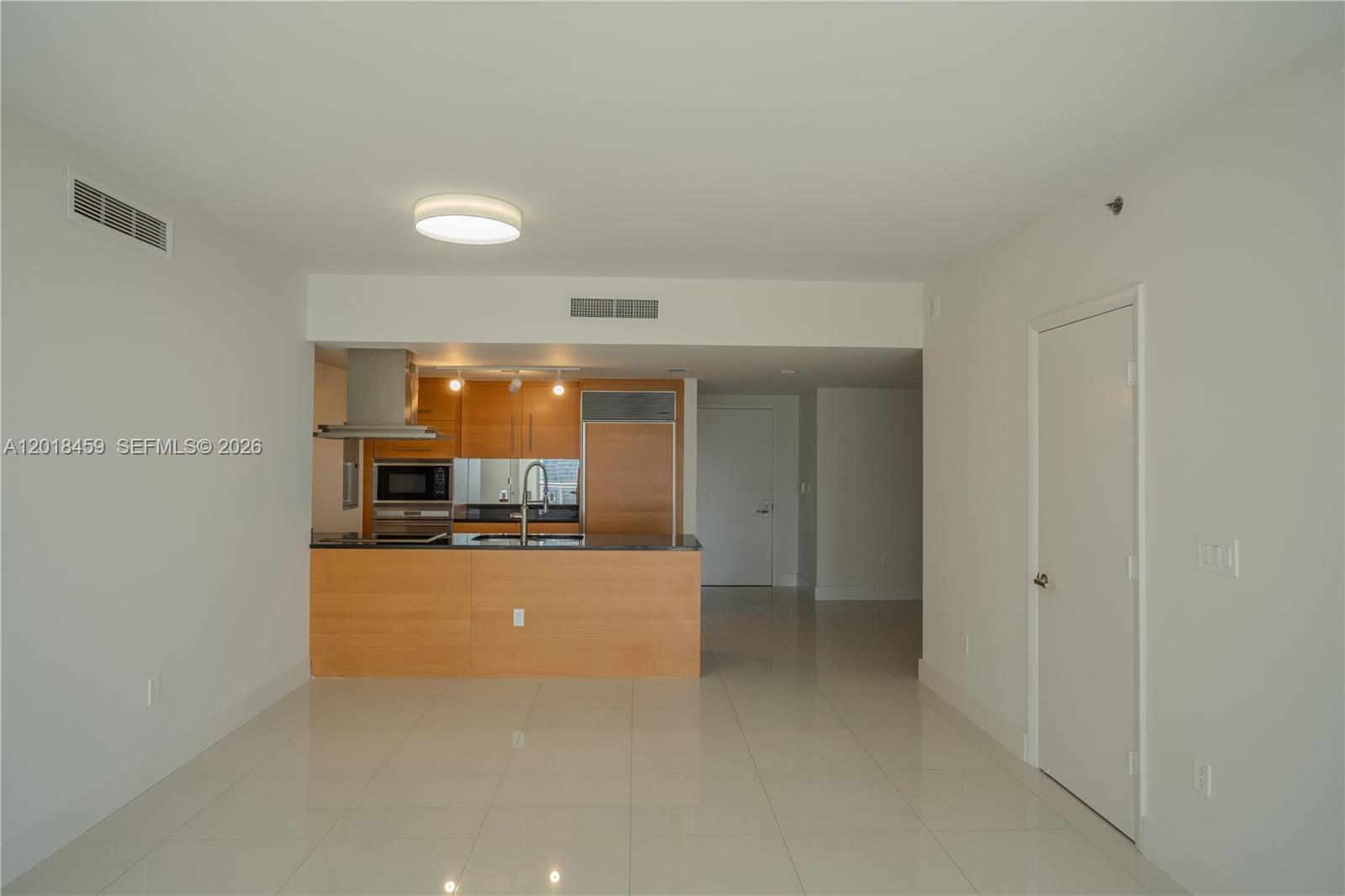 This room features a kitchen with light wood cabinets, a breakfast bar, and tile flooring — 495 Brickell Ave # 2703, Miami FL 33131, MIAMI, FL