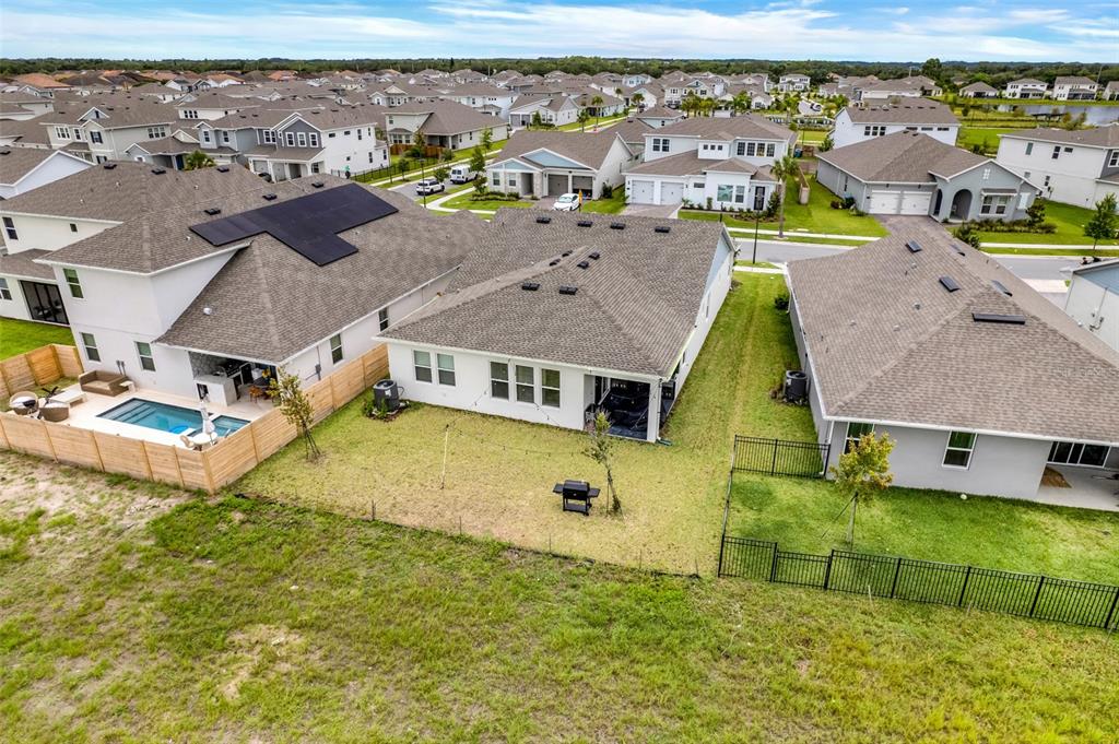 An aerial view shows three suburban houses with backyards, including one with a swimming pool — 18863 RAWSON STREET, ORLANDO, FL