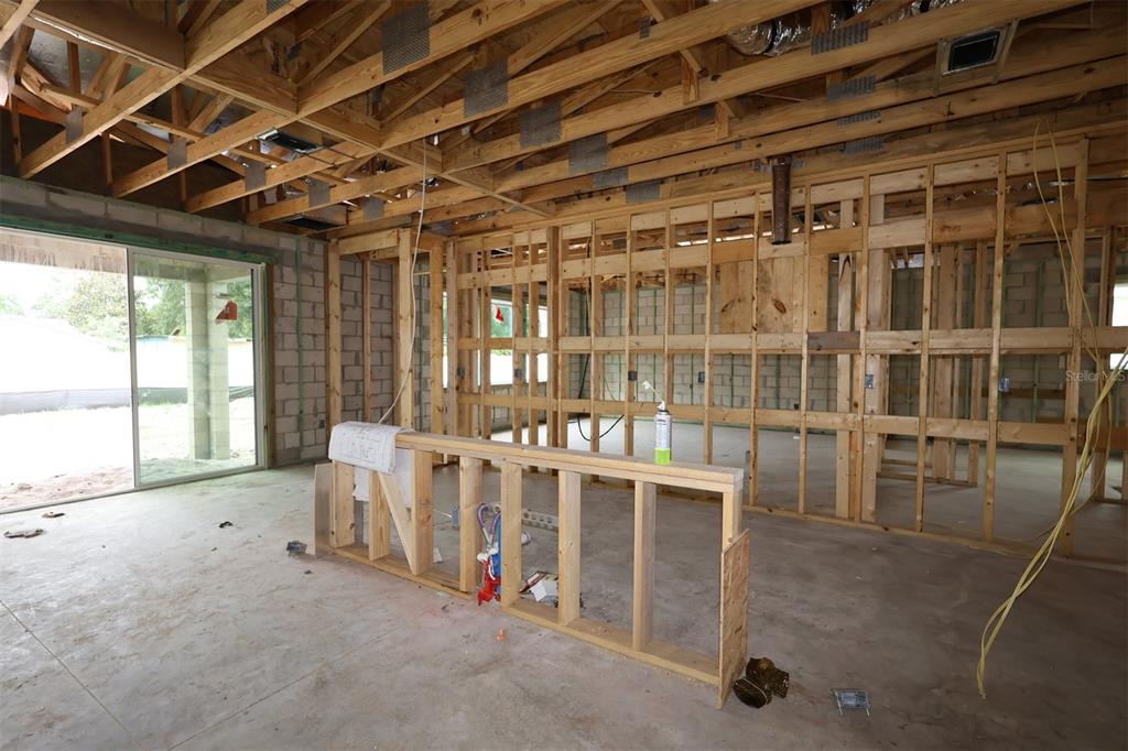 An interior view of a house under construction with exposed wooden framing and concrete floors — 2670 RAVENCLIFFE TERRACE, OVIEDO, FL