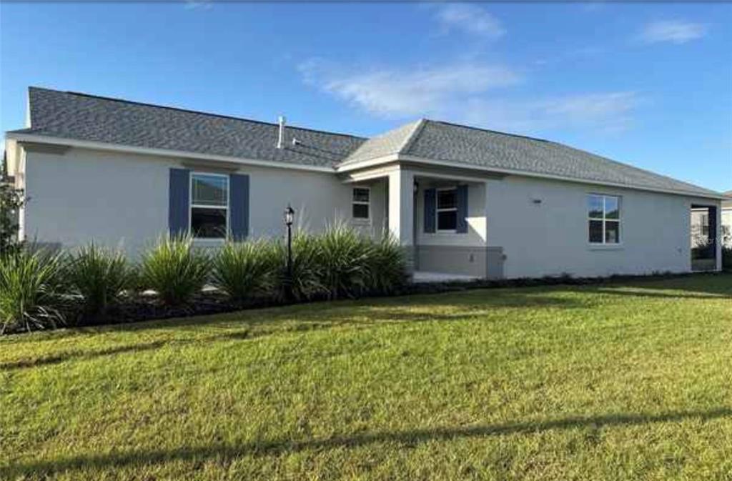 A single-story house with a gray roof, stucco exterior, and a front porch — 7204 SW 89TH AVENUE, OCALA, FL