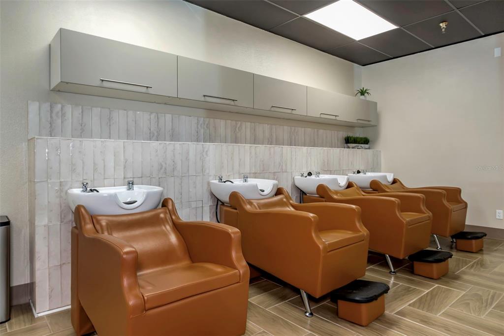 A salon shampoo area features four tan leather chairs with white basins and wall-mounted cabinets — 2554 E BEARSS AVENUE, TAMPA, FL