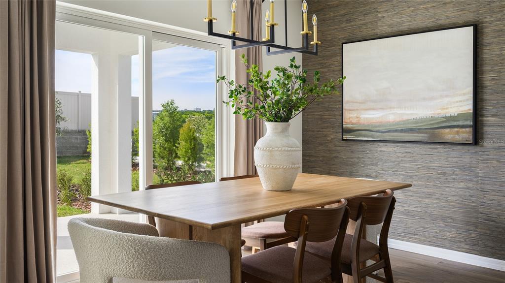 A dining room features a wooden table, textured wallpaper, and a sliding glass door view — 5444 SAN PIETRO DRIVE, WINTER HAVEN, FL
