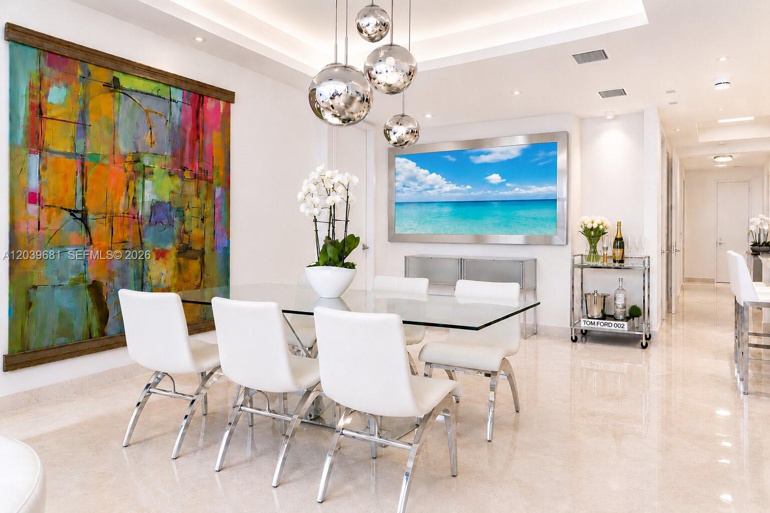 A modern dining room features a glass table, white chairs, and a large abstract painting — 100 S Pointe Dr # 1507, Miami Beach FL 33139, MIAMI BEACH, FL