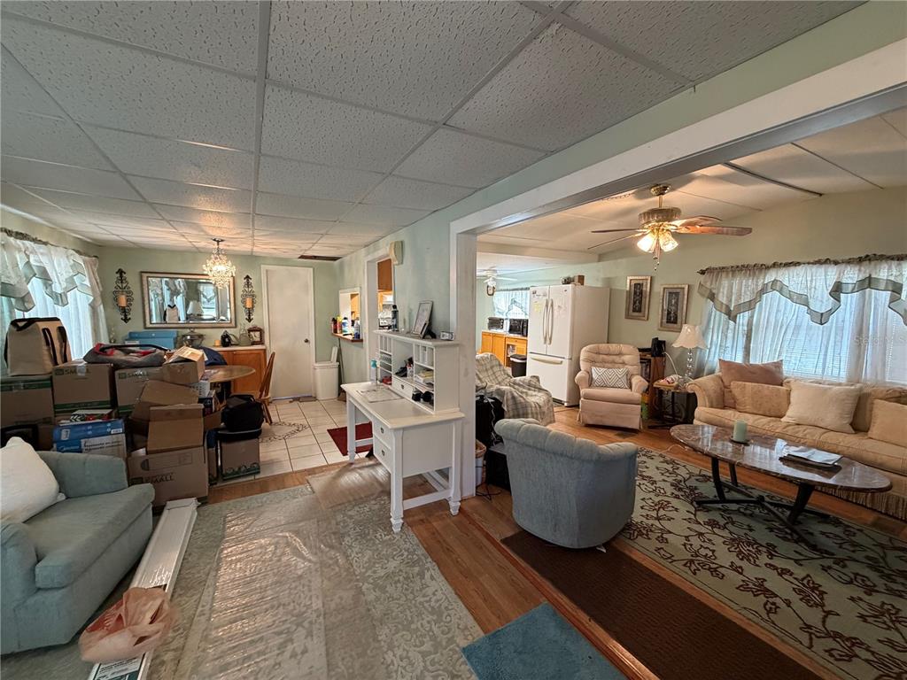 A living room and dining area feature a white desk, ceiling fans, and carpeted flooring — 111 SW 158TH TERRACE, OCALA, FL
