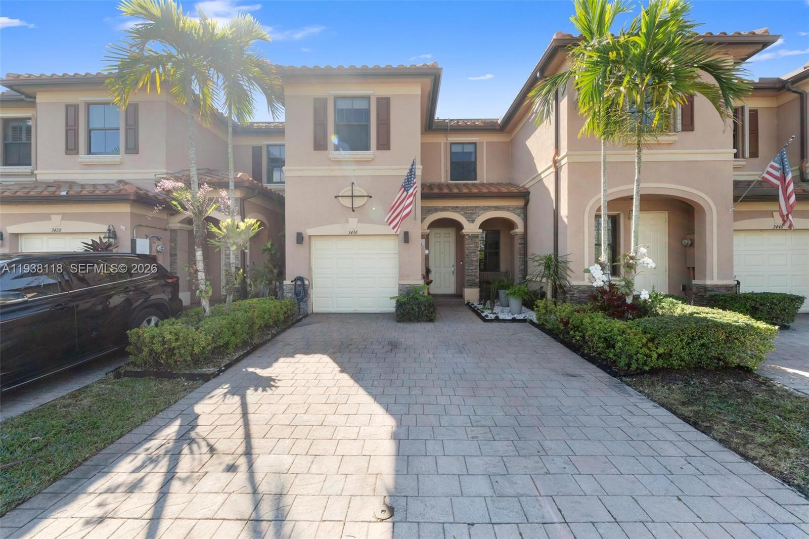 A two-story townhouse with a paved driveway, a garage, and palm trees in the front — 3436 W 90th St, Hialeah FL 33018, HIALEAH, FL