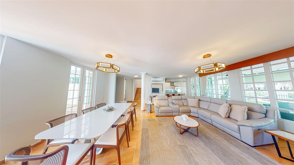 A bright open-concept living and dining area features tile floors, a sectional sofa, and chandeliers — 53 CALLE ARRECIFE, DORADO, PR