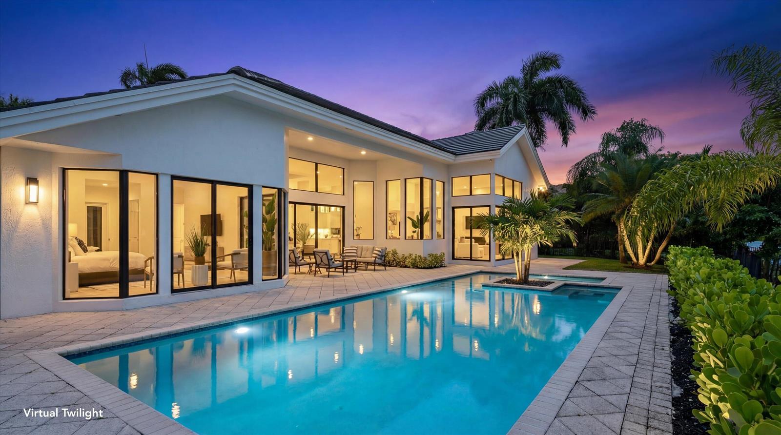 A modern house exterior with a swimming pool and patio at twilight — 1330 Breakers West Boulevard, West Palm Beach FL 33411, WEST PALM BEACH, FL