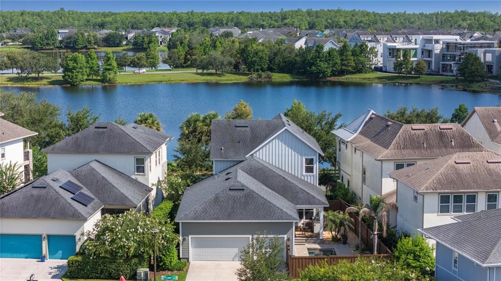 An aerial view shows several suburban houses with gray roofs situated along a lake — 13041 GABOR AVENUE, ORLANDO, FL