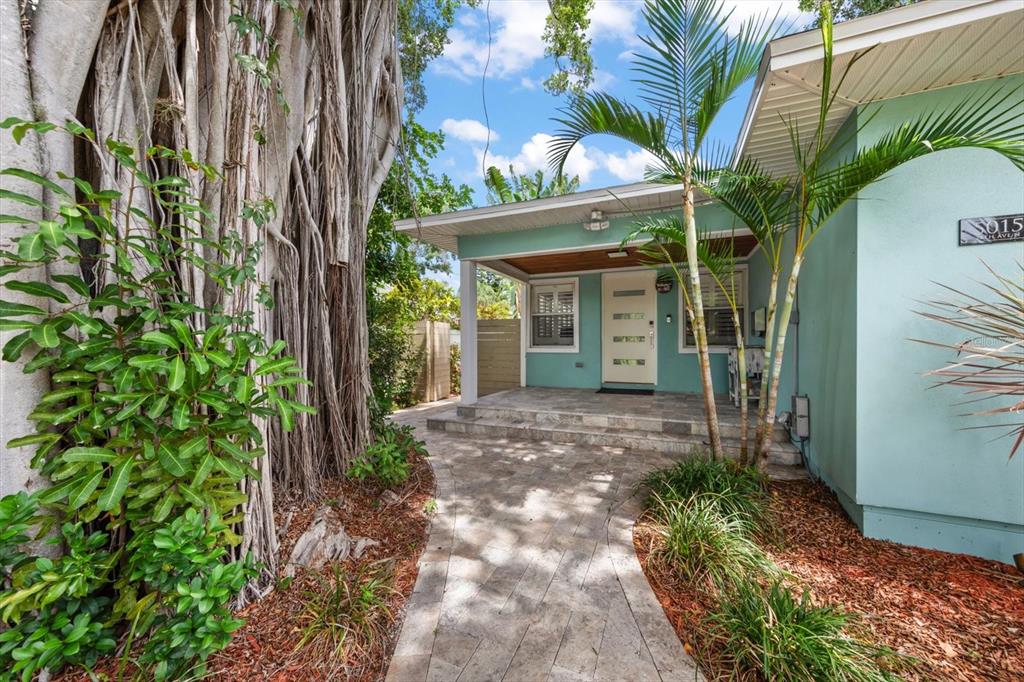 A light blue house features a stone walkway leading to a covered front porch — 5015 20TH AVENUE N, ST PETERSBURG, FL