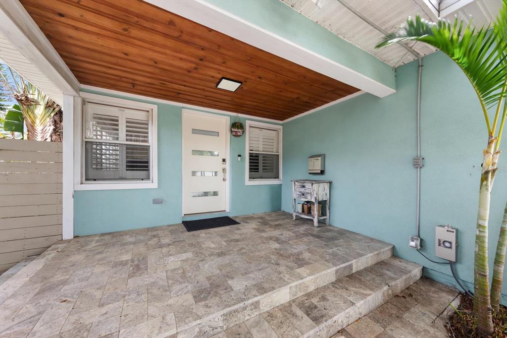 A covered front porch features light blue walls, a wood-paneled ceiling, and stone tile flooring — 5015 20TH AVENUE N, ST PETERSBURG, FL