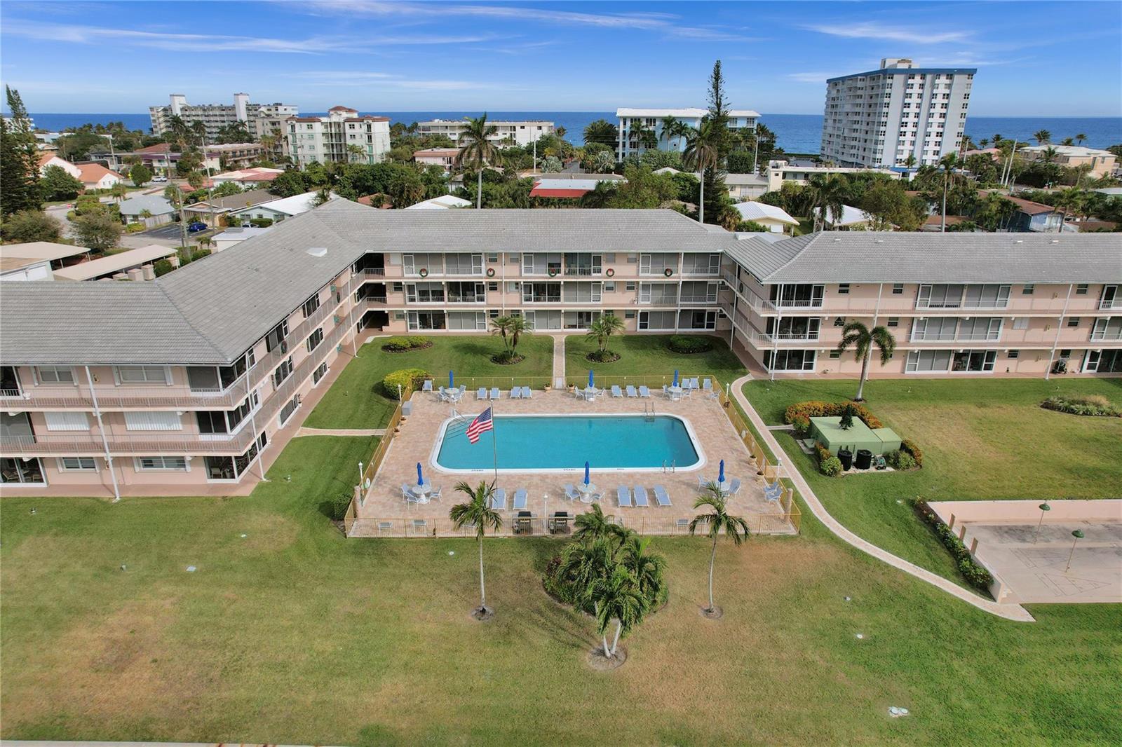 A boat travels along a canal lined with waterfront houses and palm trees — 745 SE 19th Avenue # 134, Deerfield Beach FL 33441, DEERFIELD BEACH, FL