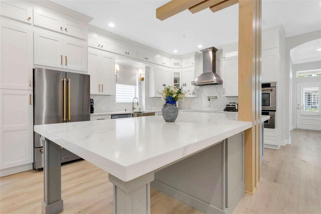 A modern kitchen features white cabinetry, a large marble island, and stainless steel appliances — 3069 STANFIELD AVENUE, ORLANDO, FL