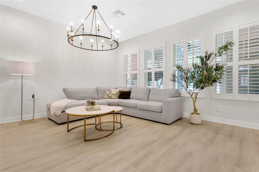A living room features a light gray sectional sofa, a round coffee table, and a chandelier — 3069 STANFIELD AVENUE, ORLANDO, FL