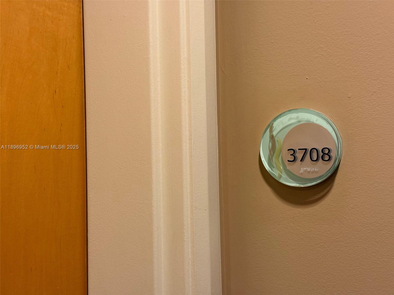 A circular room number sign for unit 3708 is mounted on a beige wall — 244 Biscayne Blvd # 3708, Miami FL 33132, MIAMI, FL