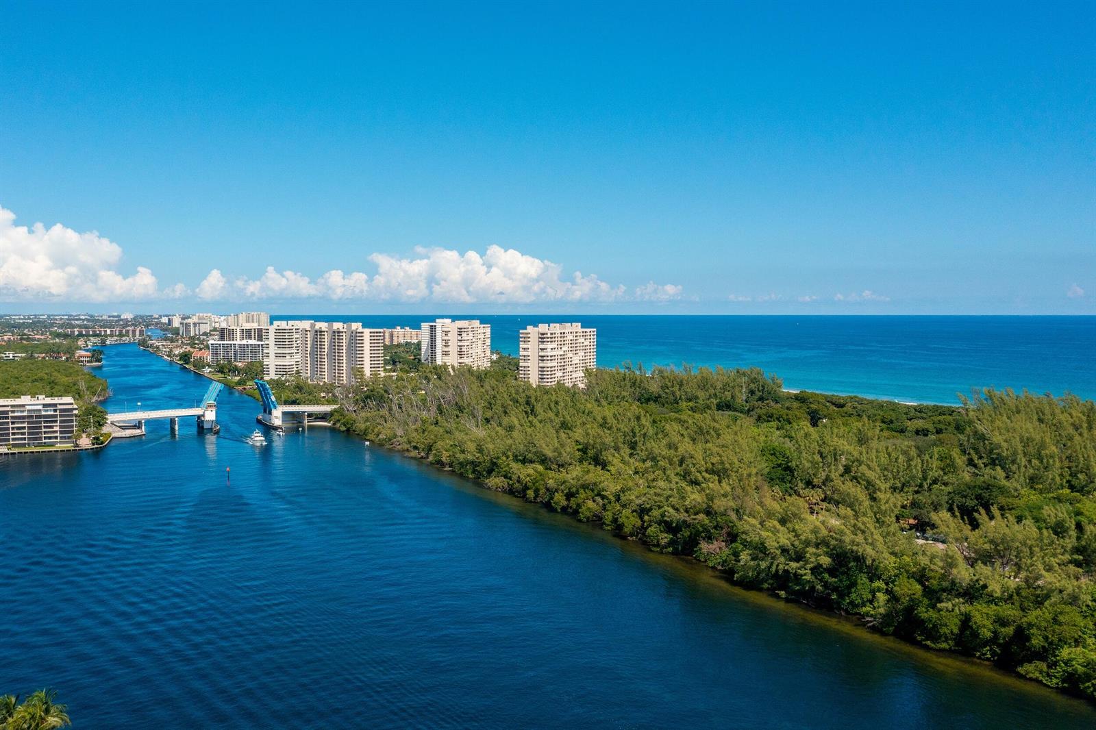 An aerial view shows a drawbridge over a waterway next to coastal high-rise buildings — 3363 NE 6th Drive, Boca Raton FL 33431, BOCA RATON, FL