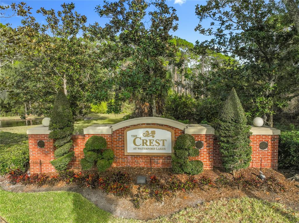 A brick monument sign for The Crest at Waterford Lakes stands in a landscaped area — 12602 CREST SPRINGS LANE UNIT 1333, ORLANDO, FL