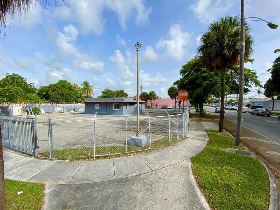 A fenced-in vacant lot features a small, gray, single-story building and a tall light pole — 1910 NW 17th Ave, Miami FL 33125, MIAMI, FL