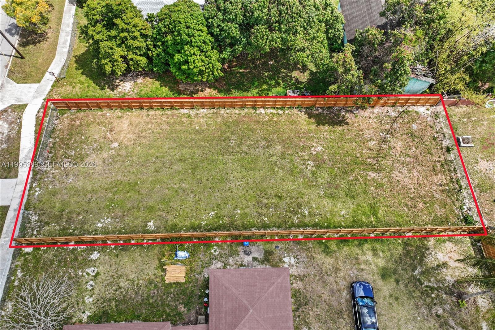 An aerial view shows a rectangular, fenced-in vacant lot covered in grass — nw 2, Florida City FL 33034, FLORIDA CITY, FL