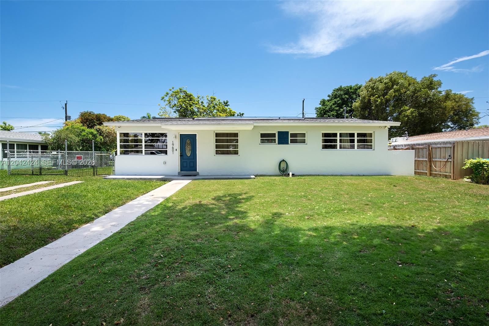 A single-story house with a white exterior, a blue front door, and a grassy lawn — 19601 Belview Dr, Cutler Bay FL 33157, CUTLER BAY, FL