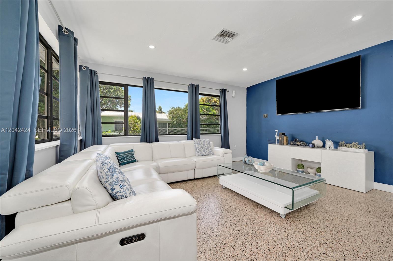 A living room features a white sectional sofa, a glass coffee table, and a blue accent wall — 19601 Belview Dr, Cutler Bay FL 33157, CUTLER BAY, FL