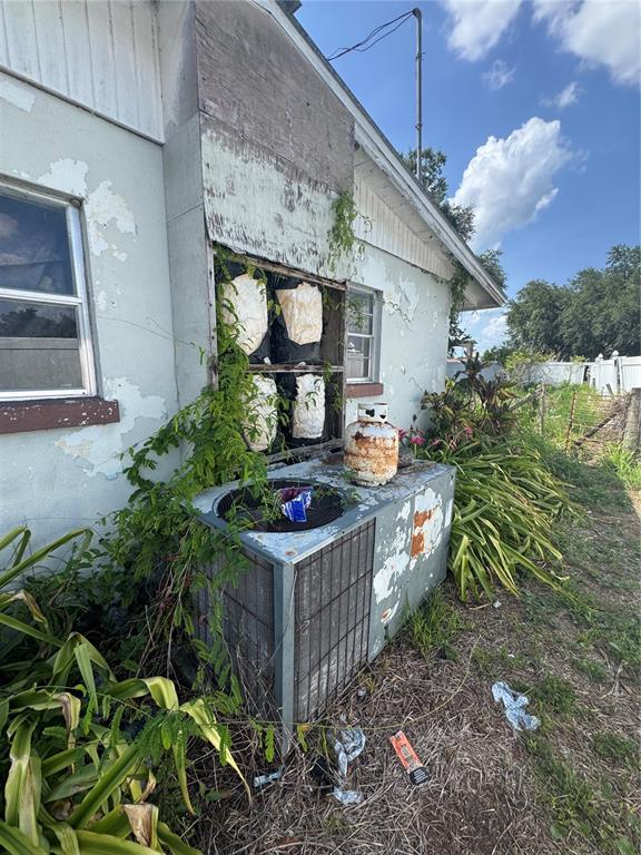 An exterior view of a house with a damaged wall, exposed insulation, and an outdoor unit — 2152 SE CARLSTROM FIELD ROAD, ARCADIA, FL