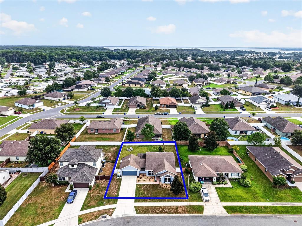 An aerial view shows a suburban single-family home highlighted by a blue border — 544 TORTOLA AVENUE, TAVARES, FL