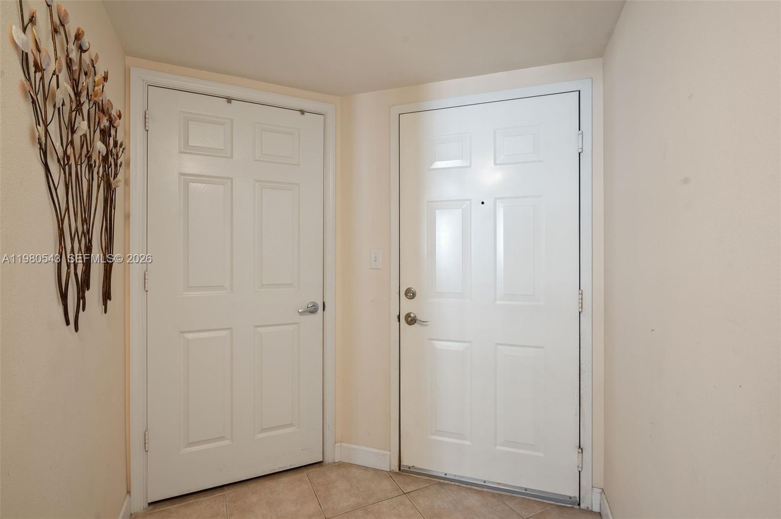 Two white interior doors are set in a corner with tiled flooring and wall decor — 2080 S Ocean Dr # 1402, Hallandale Beach FL 33009, HALLANDALE BEACH, FL