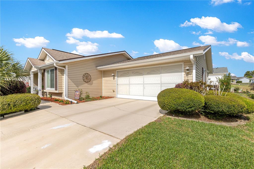 A tan, single-story house with a two-car garage and a concrete driveway — 8145 SW 108 STREET, OCALA, FL