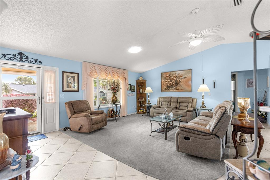 A living room features light blue walls, a gray carpet, and a tan sofa set — 8145 SW 108 STREET, OCALA, FL
