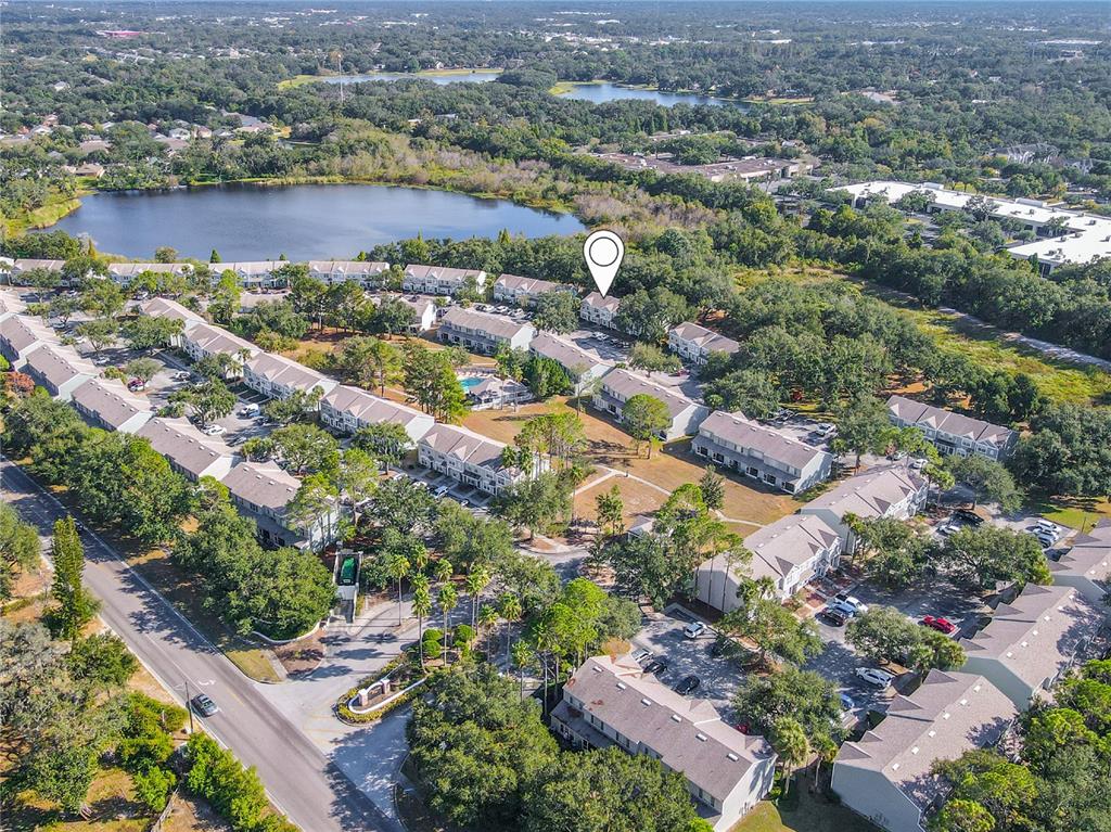An aerial view of a multi-family residential complex featuring townhouses, parking lots, and a lake — 2432 LAKE WOODBERRY CIRCLE, BRANDON, FL