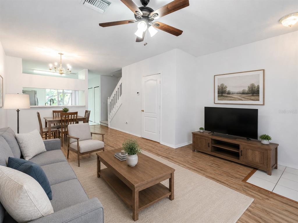 A living room with wood flooring, a gray sofa, a coffee table, and a television — 2432 LAKE WOODBERRY CIRCLE, BRANDON, FL