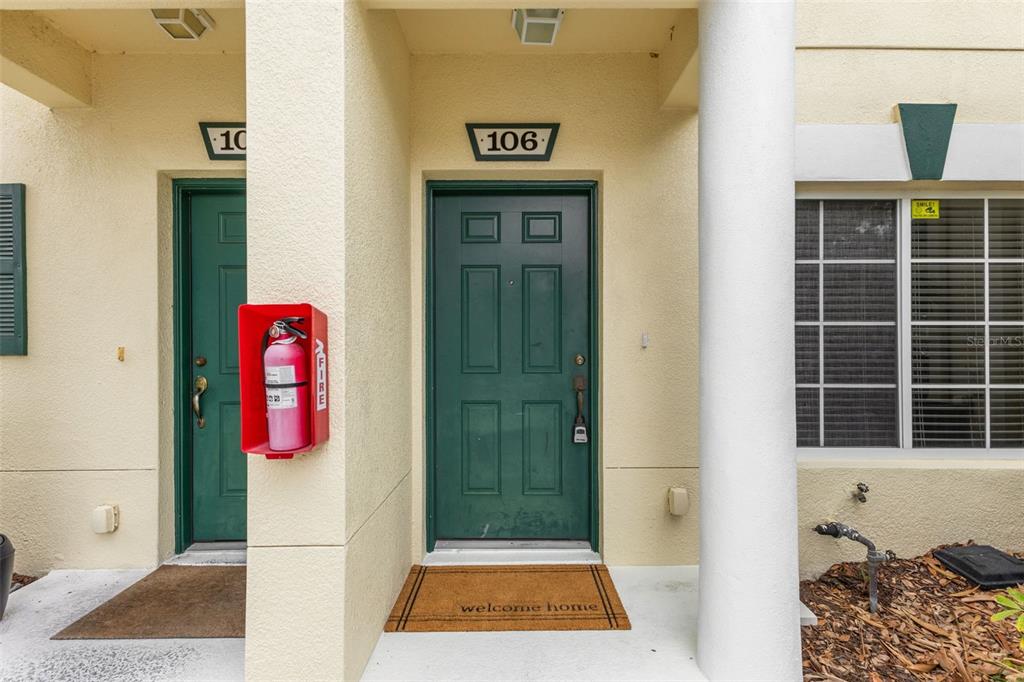 The exterior entrance of a residential unit features a green door labeled 106 — 354 CAPE HARBOUR LOOP UNIT 106, BRADENTON, FL