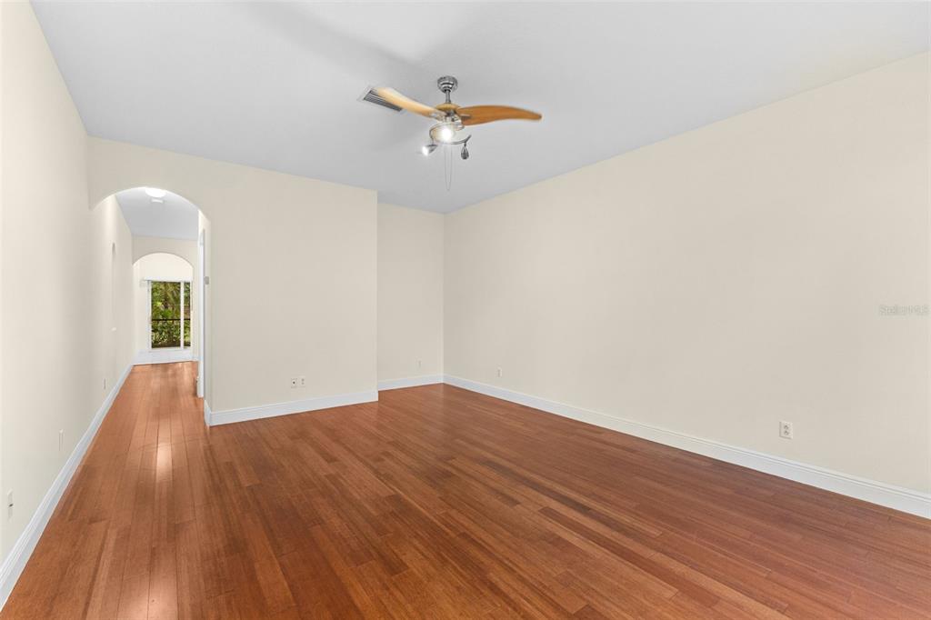 An empty room with hardwood floors, white walls, and a ceiling fan — 354 CAPE HARBOUR LOOP UNIT 106, BRADENTON, FL