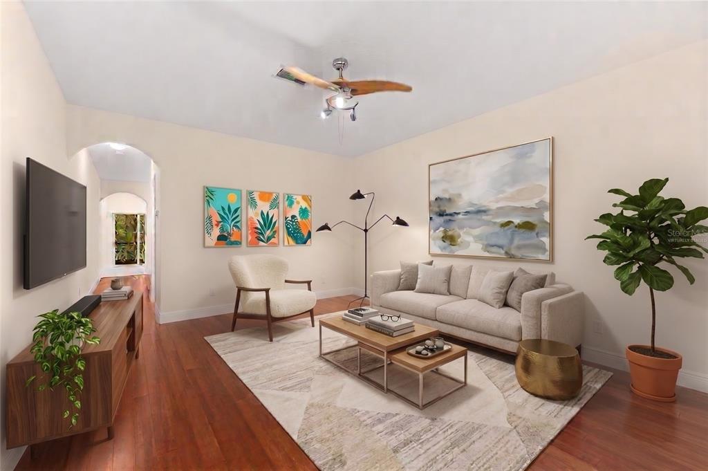 This living room features a sofa, armchair, coffee tables, wall art, and a ceiling fan — 354 CAPE HARBOUR LOOP UNIT 106, BRADENTON, FL