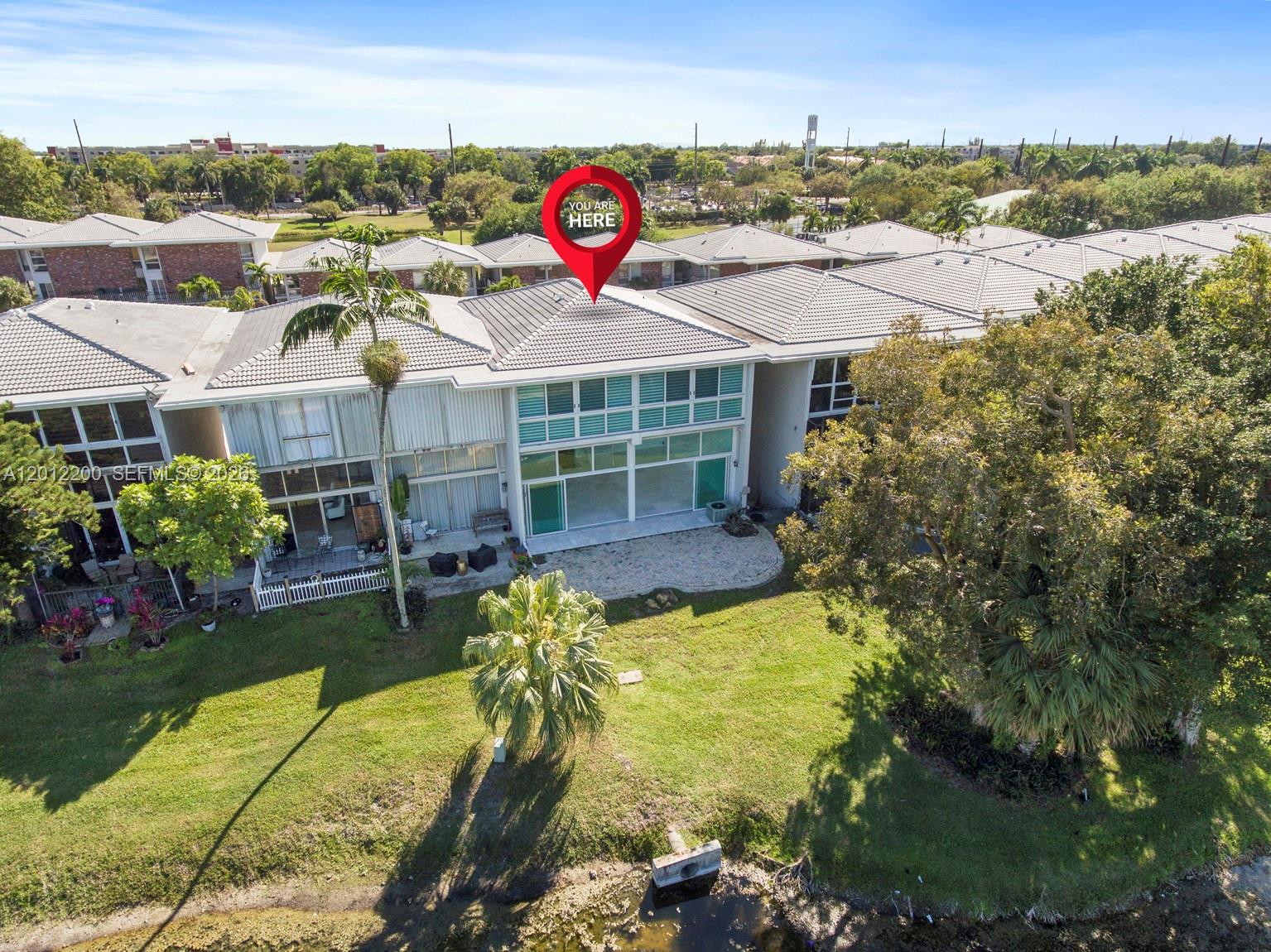 An aerial view shows a row of townhouses with a backyard facing a pond — 6795 Brookline Dr # 6795, Miami FL 33015, MIAMI, FL