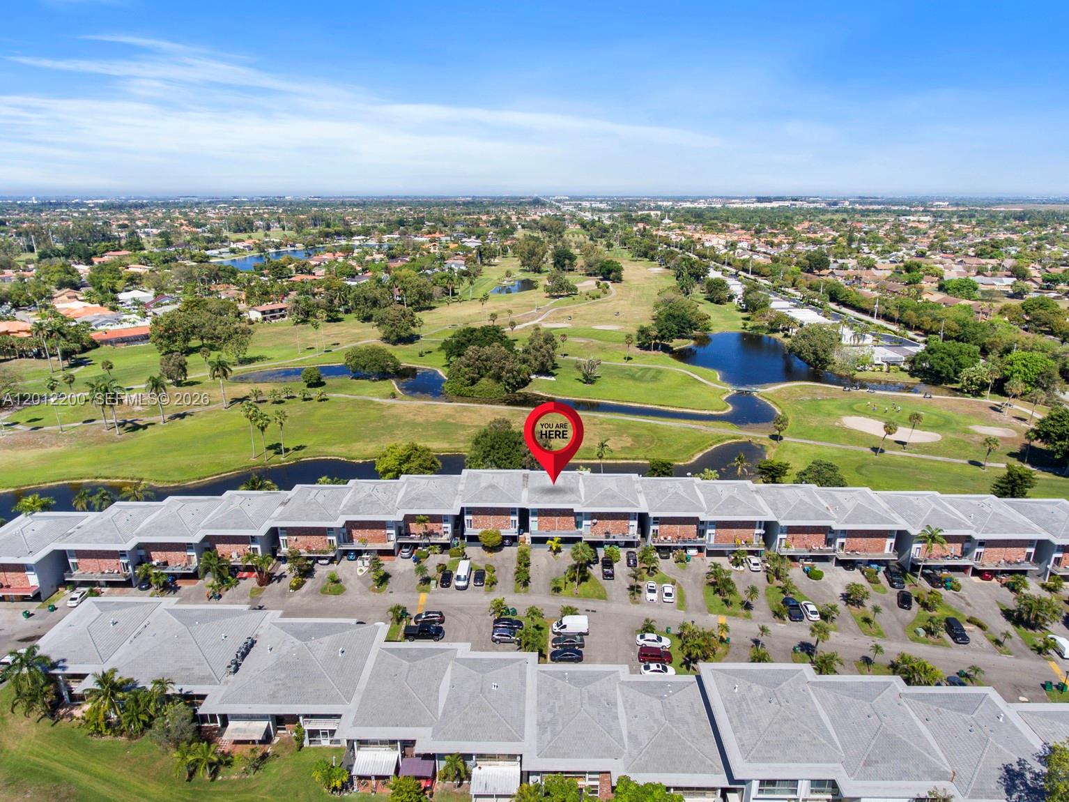 This aerial view shows a multi-unit residential complex overlooking a golf course and ponds — 6795 Brookline Dr # 6795, Miami FL 33015, MIAMI, FL