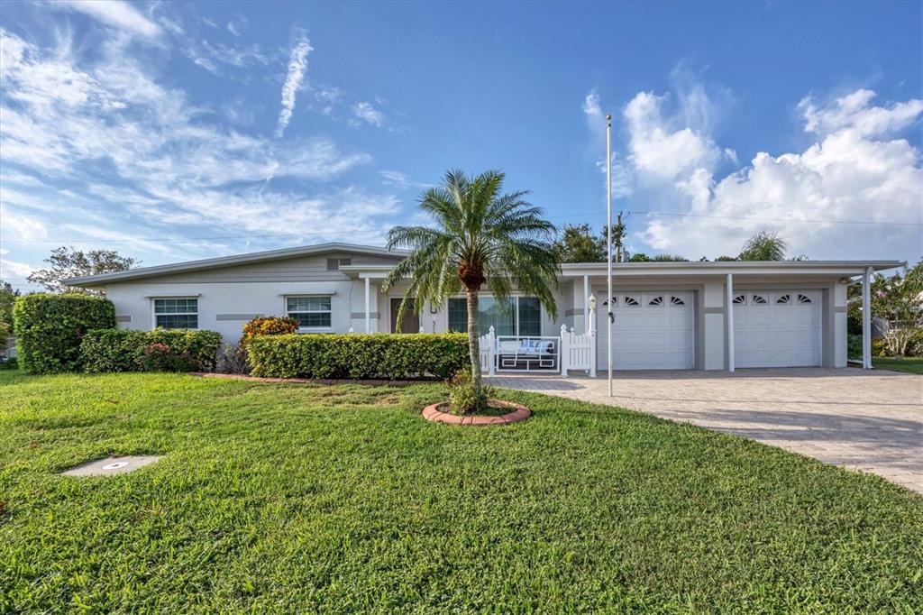 A single-story house with a two-car garage, a palm tree, and a manicured lawn — 3126 BOUGAINVILLEA STREET, SARASOTA, FL