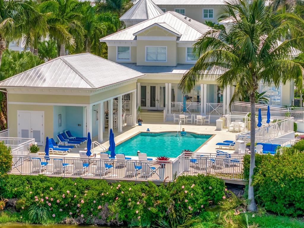 An aerial view of a house with a swimming pool, patio furniture, and palm trees — 7840 34TH AVENUE W UNIT 202, BRADENTON, FL