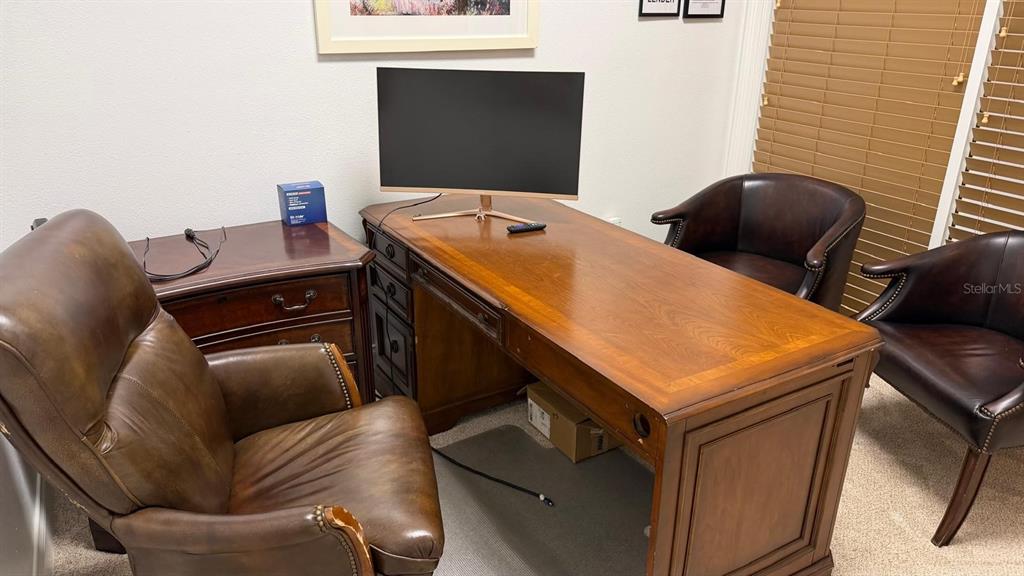 A home office features a wooden desk, a leather executive chair, and two guest chairs — 7901 KINGSPOINTE PARKWAY UNIT 8, ORLANDO, FL