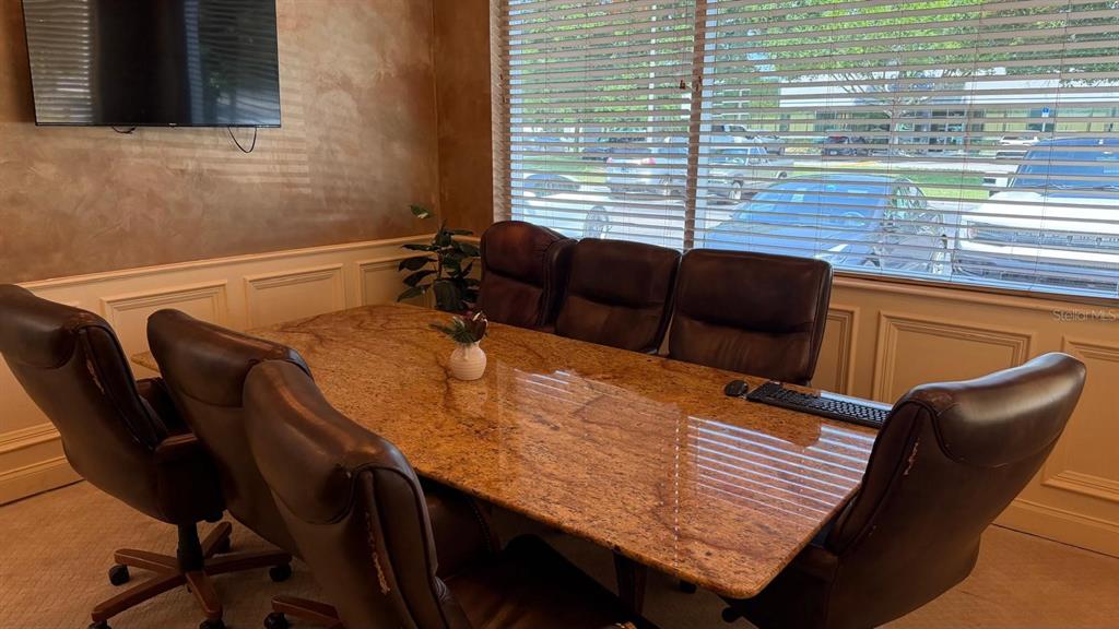A conference room features a large granite table, brown leather chairs, and window blinds — 7901 KINGSPOINTE PARKWAY UNIT 8, ORLANDO, FL